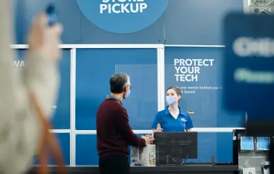 Female Best Buy employee assisting customer at store pick up